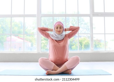 Young Pregnant Muslim Woman Exercising On Mat In Gym