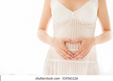  Young Pregnant in white dress doing with fingers Heart symbol