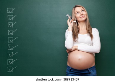 Young pregnant woman and a blackboard with copyspace