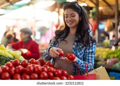 Young pregnant woman buying on a street market