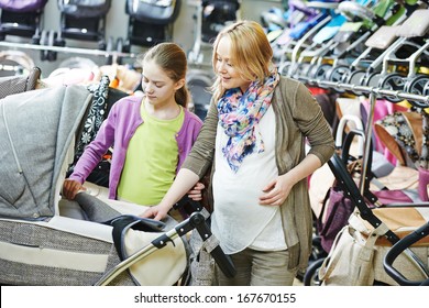 Young Pregnant Woman Choosing Baby Carriage Or Pram Buggy For Newborn At Shop Store