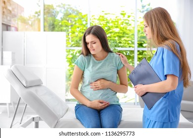 Young pregnant woman with depression and her doctor in clinic