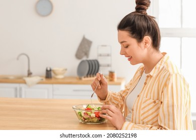 Young pregnant woman eating healthy salad at home - Shutterstock ID 2080252198