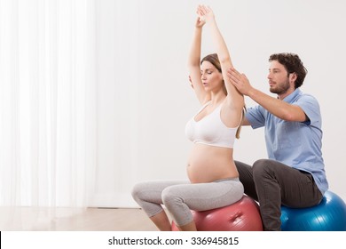 Young Pregnant Woman Exercising At Antenatal Class