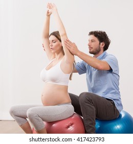 Young Pregnant Woman Exercising At Antenatal Class