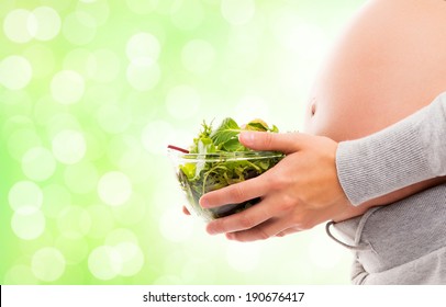 A Young And Pregnant Woman With A Fresh Green Salad.