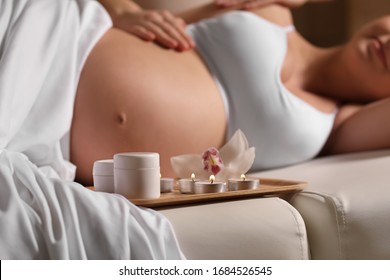 Young Pregnant Woman Having Massage In Spa Salon