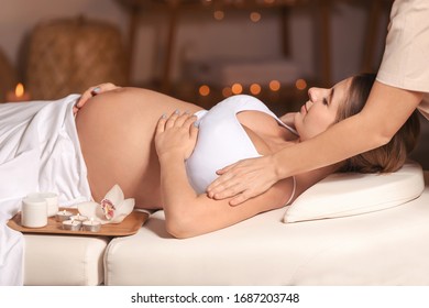 Young pregnant woman having massage in spa salon - Powered by Shutterstock