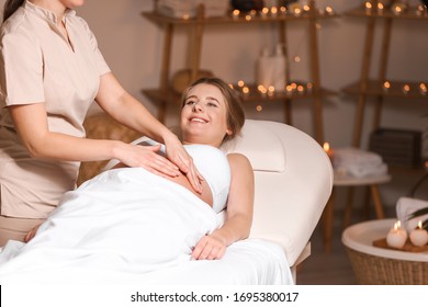 Young Pregnant Woman Having Massage In Spa Salon