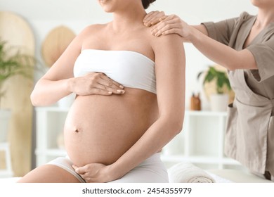 Young pregnant woman having massage in spa salon, closeup - Powered by Shutterstock