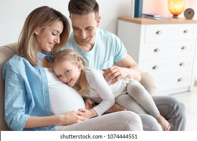 Young Pregnant Woman With Her Family At Home