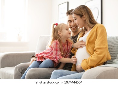 Young Pregnant Woman With Her Family At Home