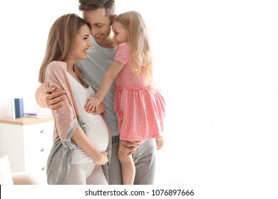 Young Pregnant Woman With Her Family At Home