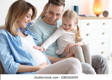 Young Pregnant Woman With Her Family At Home