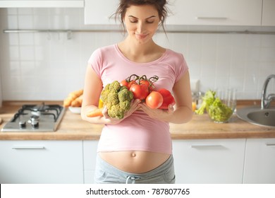 Young Pregnant Woman In The Kitchen At Home Healthy Food