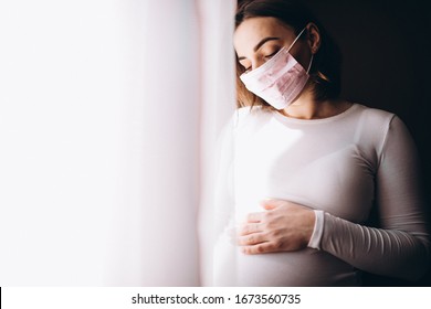 Young pregnant woman in medical mask
