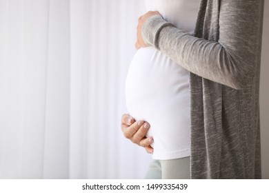 Young pregnant woman near window, closeup - Shutterstock ID 1499335439