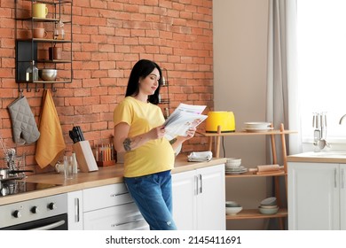 Young pregnant woman reading newspaper in kitchen - Powered by Shutterstock