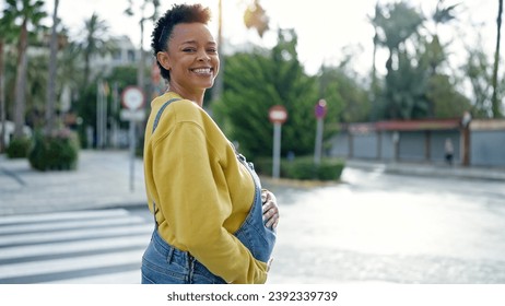 Young pregnant woman smiling confident touching belly at street - Powered by Shutterstock