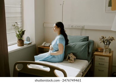 Young pregnant woman sunbathing in hospital ward and enjoying moment - Powered by Shutterstock