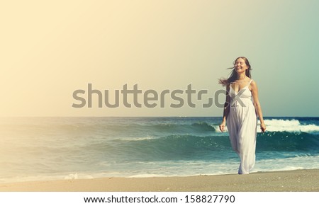 Young pregnant woman walking at the beach