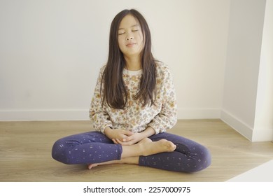 Young preteen girl barefoot practiceing yoga and meditating, mindfulness, positive mental health concept - Shutterstock ID 2257000975