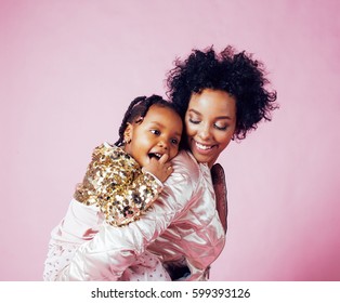 young pretty african-american mother with little cute daughter hugging, happy smiling on pink background, lifestyle modern people concept 