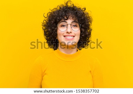 young pretty afro woman looking happy and goofy with a broad, fun, loony smile and eyes wide open