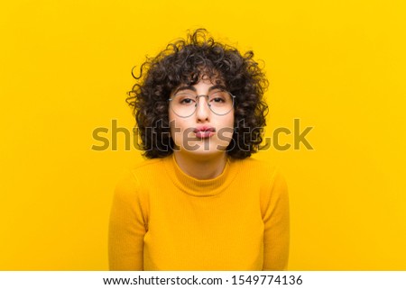 young pretty afro woman pressing lips together with a cute, fun, happy, lovely expression, sending a kiss