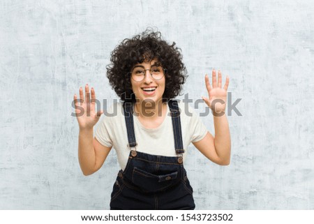 young pretty afro woman screaming in panic or anger, shocked, terrified or furious, with hands next to head