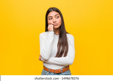 Young pretty arab woman against a yellow background who feels sad and pensive, looking at copy space.