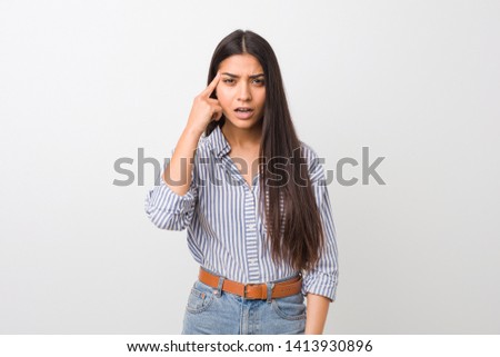 Young pretty arab woman showing a disappointment gesture with forefinger.