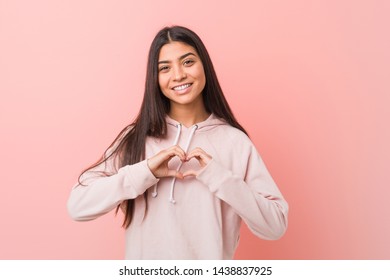 Young pretty arab woman wearing a casual sport look smiling and showing a heart shape with hands. - Shutterstock ID 1438837925