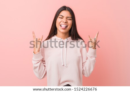 Young pretty arab woman wearing a casual sport look showing rock gesture with fingers