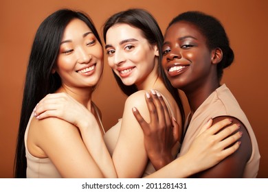 young pretty asian, caucasian, afro woman posing cheerful together on brown background, lifestyle diverse nationality people concept - Shutterstock ID 2011281431