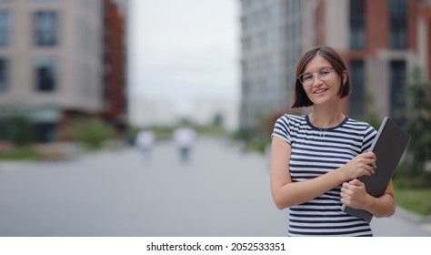 Young Pretty Asian Woman Walking With Laptop In Modern City Street On Remote IT Work, Summer Style Casual Smiling