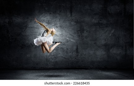 Young Pretty Ballerina Girl Making Jump In Dance