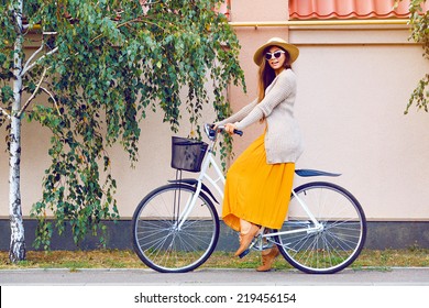 Young Pretty Beautiful Woman Riding Her White Retro Hipster Bike,wearing Stylish Vintage Clothes Sunglasses And Straw Hat, Fashion Fall Autumn Portrait Of Elegant Lady Having Fun Outdoor.