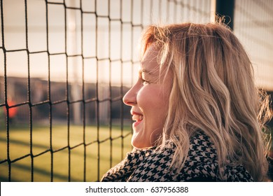 Young Pretty Blond Hair Smiling Woman - Football Fan Portrait. Aunt Cheers For Her Nephew Playing Soccer On Local Green Field. Parents Picking Up Kids From Their After School Activities - Concept