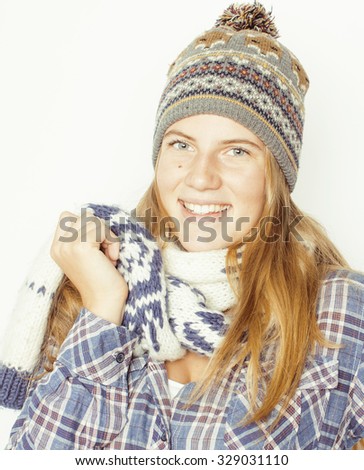 young pretty blond teenage girl in winter hat and scarf on white background smiling close up isolated