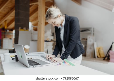 young, pretty, blonde architect is planning on the notebook and tablet the expansion of a loft - Shutterstock ID 792093067