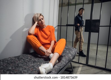 A young pretty blonde prisoner in a general regime prison is sitting in a solitary cell.