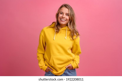 young pretty blonde woman cute face expression posing in yellow hoodie on pink bright background isolated, emotional, funny - Powered by Shutterstock