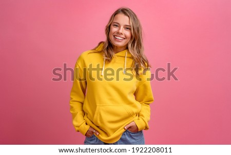 young pretty blonde woman cute face expression posing in yellow hoodie on pink bright background isolated, emotional, funny