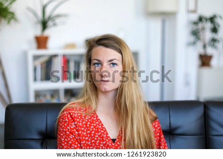 Similar – Entrepreneur woman wearing red shirt working with a laptop sitting on a couch at home