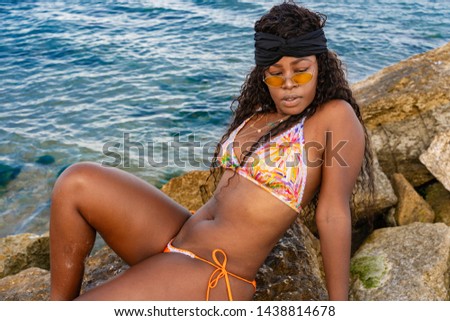 Young pretty brasilian girl with black long curly hair on the beach sea coast