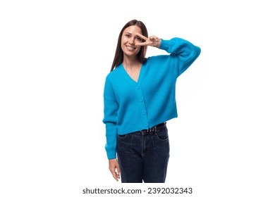 young pretty brunette lady dressed in a blue V-neck sweater on a white background with copy space
