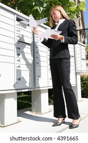 A Young Pretty Business Woman Getting The Mail From The Mailbox