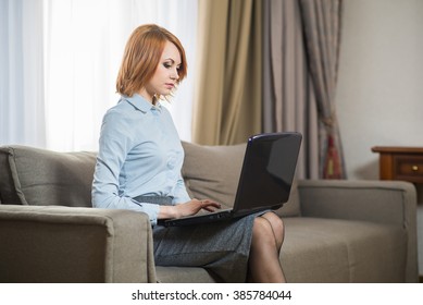 Young Pretty Business Woman With Laptop Sitting On Couch In The Hotel Room