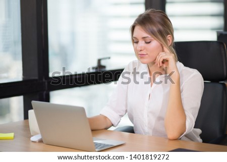 Young pretty business woman working on laptop computer or notebook in the office.